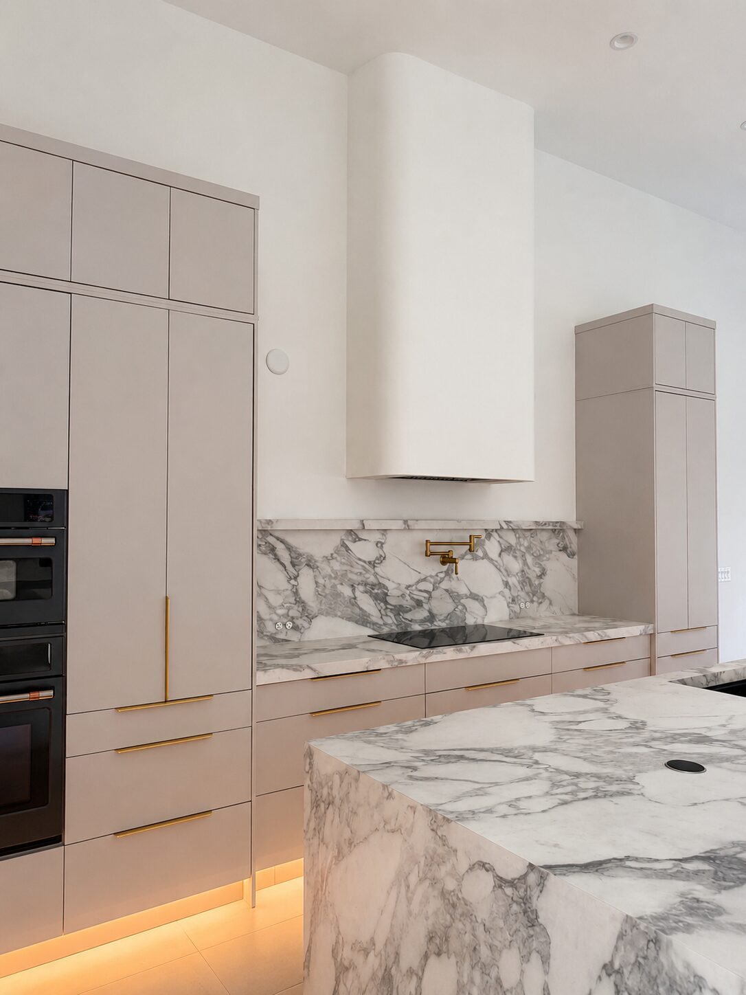 Luxury custom kitchen with marble waterfall island and plaster range hood in Naples